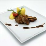 Geschmorte Schweinemedaillons mit gemischten Pilzen und Kartoffeln in Rosmarinrahmsoße