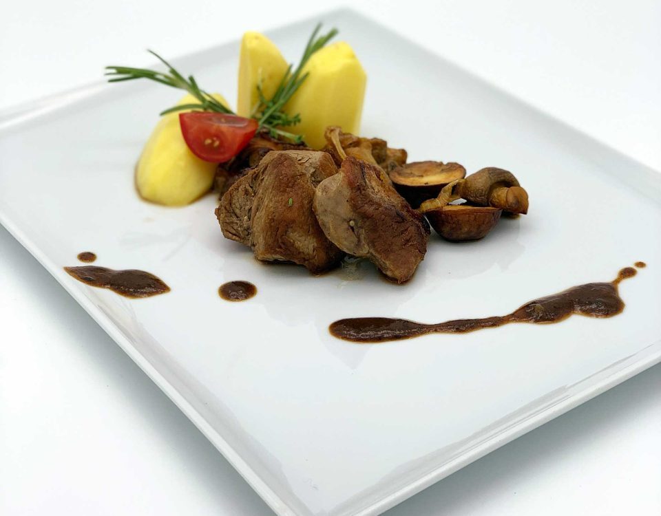 Geschmorte Schweinemedaillons mit gemischten Pilzen und Kartoffeln in Rosmarinrahmsoße