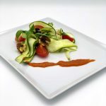Zucchininudeln in Butter geschwenkt mit Basilikum, gehakten Wallnüssen, Tomatenwürfeln und Tomatensoße
