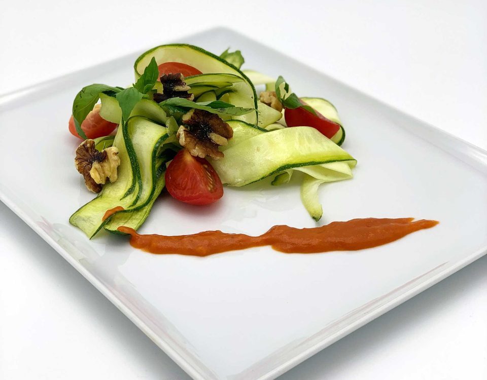 Zucchininudeln in Butter geschwenkt mit Basilikum, gehakten Wallnüssen, Tomatenwürfeln und Tomatensoße
